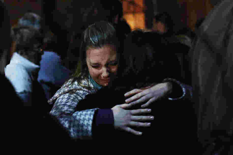 People grieve outside the overflow area of a vigil at the Saint Rose of Lima church in Newtown, Conn., on Friday following the mass shooting at the Sandy Hook Elementary School.