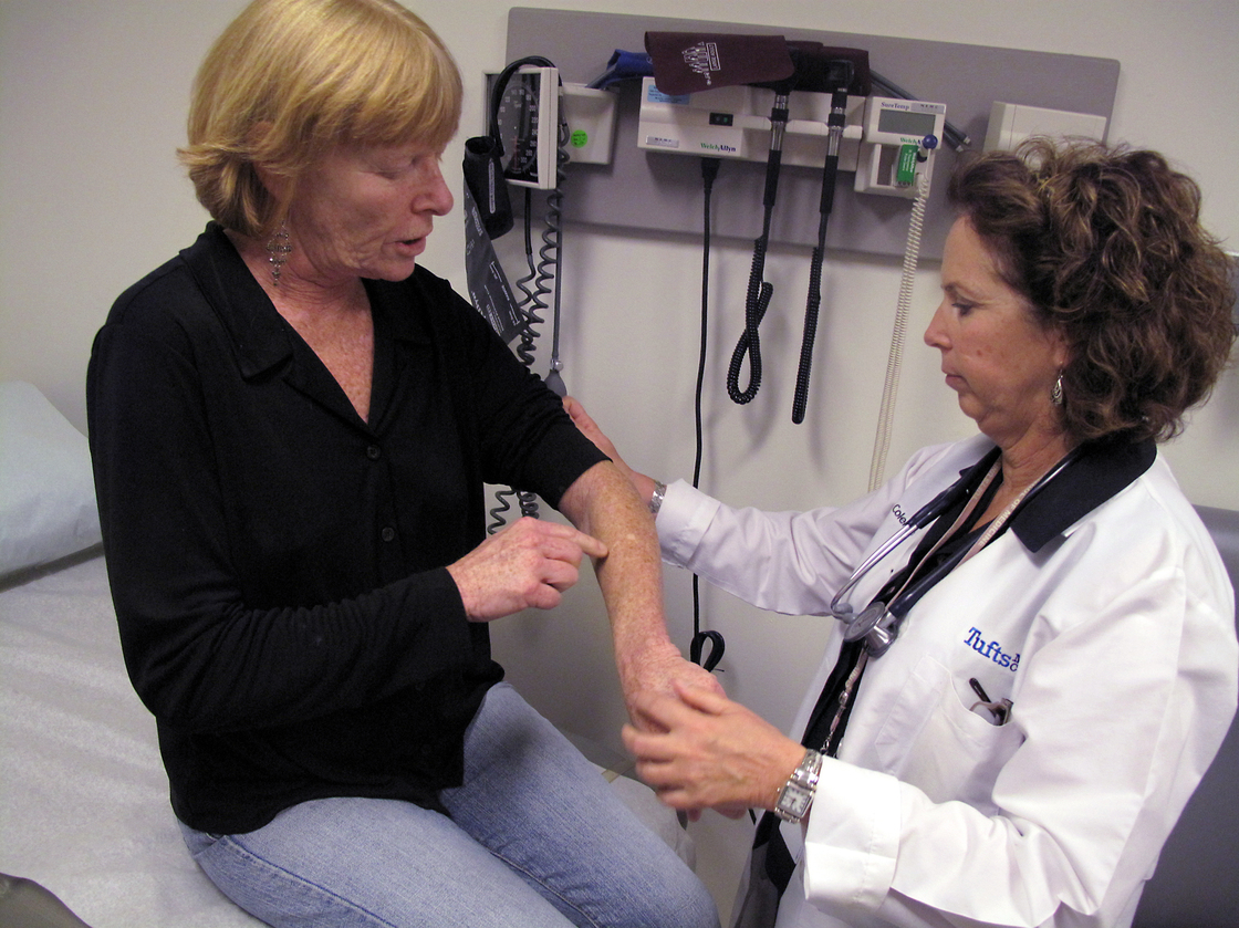 Hepatitis C patient Nancy Turner shows Kathleen Coleman, a nurse practitioner, where a forearm rash, a side effect of her treatment, has healed. Turner is one of many patients with hepatitis C experimenting with new drugs to beat back the virus.