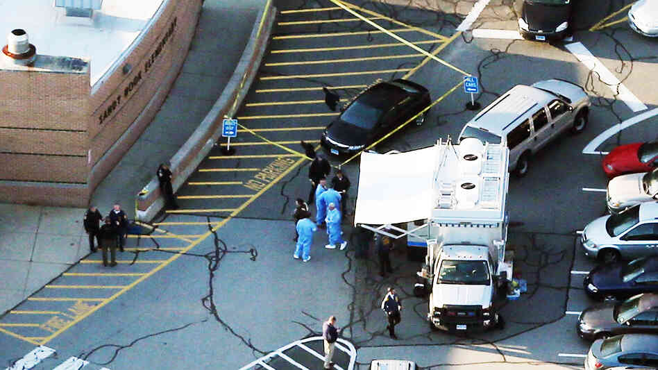 Police and medical staff work outside Sandy Hook Elementary School in Newtown, Conn., where 27 people — 20 of them children — were killed Friday morning. Police have not officially declared a suspect, but news accounts have named Adam Lanza, 20, as the suspected gunman.