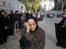 Women wait in line outside a polling station to vote on a disputed constitution drafted by Islamist supporters of President Mohammed Morsi in Cairo on Saturday.