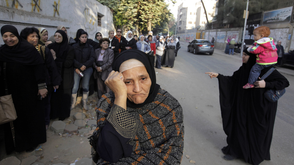 Women wait in line outside a polling station to vote on a disputed constitution drafted by Islamist supporters of President Mohammed Morsi in Cairo on Saturday.
