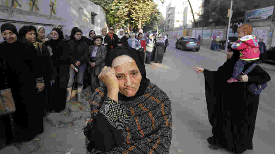 Women wait in line outside a polling station to vote on a disputed constitution drafted by Islamist supporters of President Mohammed Morsi in Cairo on Saturday.