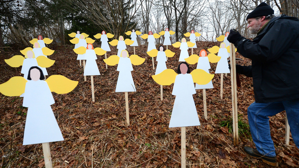 On a hillside in Newtown, Conn., art teacher Eric Mueller sets up wooden angels in memory of the victims of the Sandy Hook Elementary School shooting. Details about the lives of the slain are showing the depths of the community's loss. On a hillside in Newtown, Conn., art teacher Eric Mueller sets up wooden angels in memory of the victims of the Sandy Hook Elementary School shooting. Details about the lives of the slain are showing the depths of the community's loss.