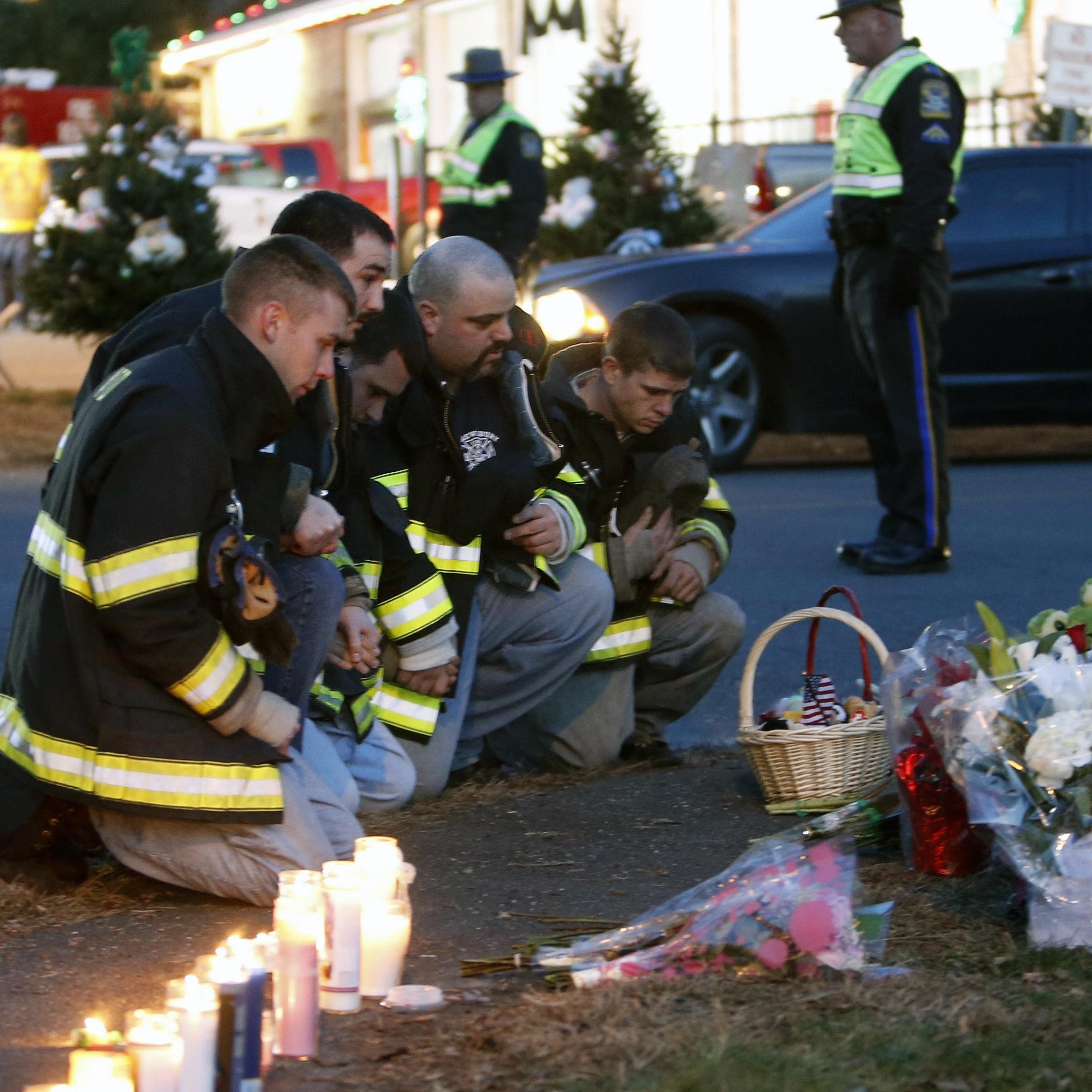Firefighters pay their respects at a memorial for shooting victims near Sandy Hook Elementary School on Saturday.