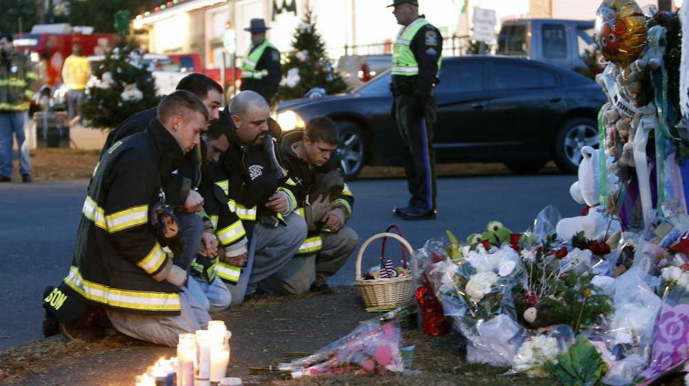 Firefighters pay their respects at a memorial for shooting victims near Sandy Hook Elementary School on Saturday. Firefighters pay their respects at a memorial for shooting victims near Sandy Hook Elementary School on Saturday.