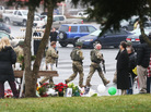 State Police officers pass a makeshift memorial as they respond to a threatening phone call that caused the evacuation of St. Rose of Lima Roman Catholic Church in Newtown during Sunday services. State Police officers pass a makeshift memorial as they respond to a threatening phone call that caused the evacuation of St. Rose of Lima Roman Catholic Church in Newtown during Sunday services.