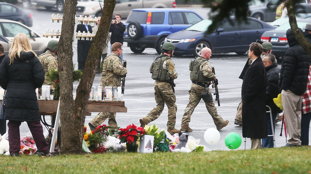State Police officers pass a makeshift memorial as they respond to a threatening phone call that caused the evacuation of St. Rose of Lima Roman Catholic Church in Newtown during Sunday services. State Police officers pass a makeshift memorial as they respond to a threatening phone call that caused the evacuation of St. Rose of Lima Roman Catholic Church in Newtown during Sunday services.