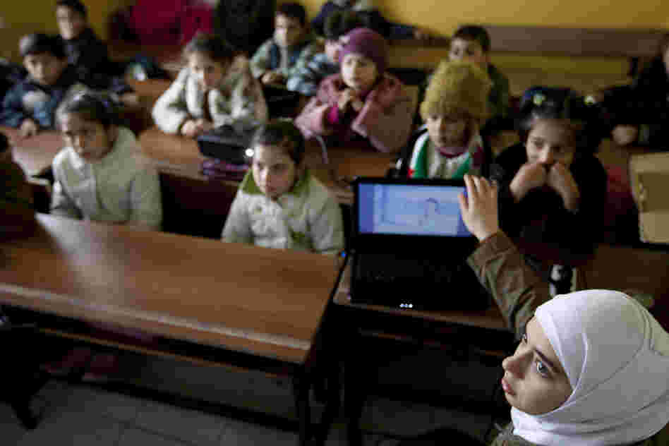 Teacher Rahaf Al Tinawie sets up a DVD player to show a video-story to her students. Tinawie teaches human resources at Albashayer and tries to help the children overcome the trauma most have experienced.