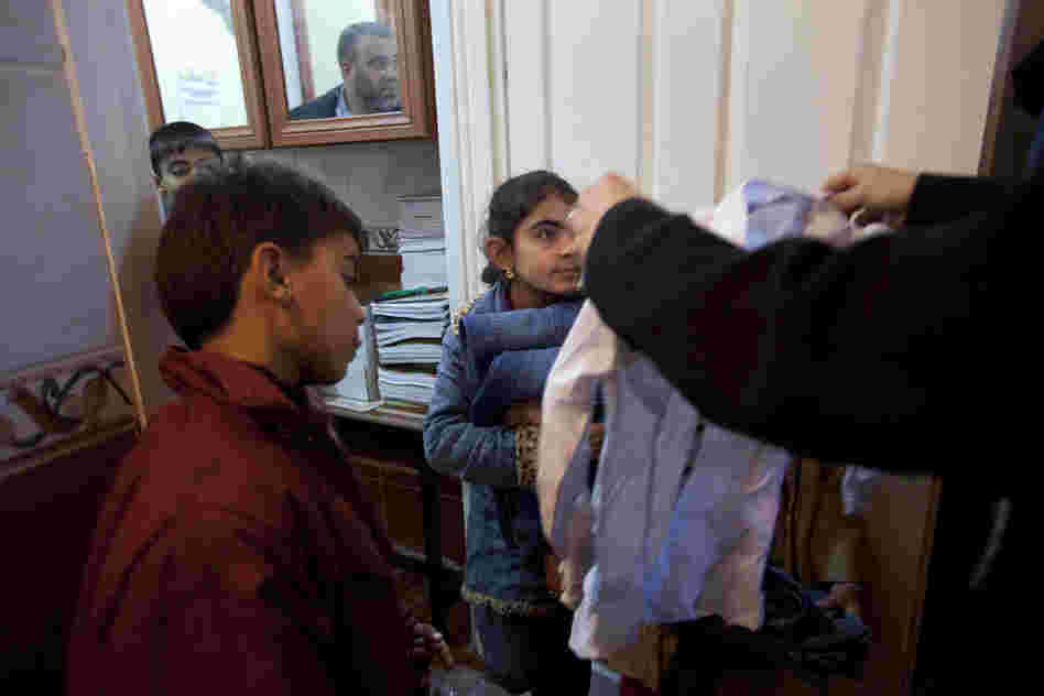 Cousins Suleiman Selmo, 9, and Kawthar Selmo, 10, receive donated clothes on their second day at the school. Many Syrian children and families are in need of basic supplies.