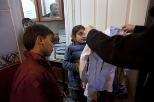 Cousins Suleiman Selmo, 9, and Kawthar Selmo, 10, receive donated clothes on their second day at the school. Many Syrian children and families are in need of basic supplies.