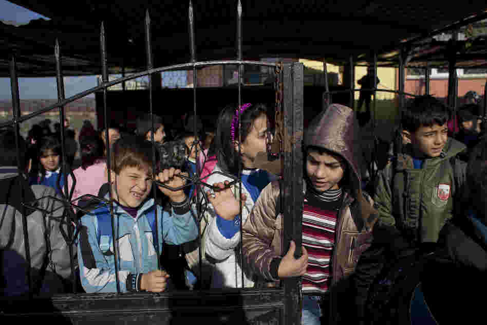 Children wait for minibuses to take them home after school. The school is free for Syrian children living in Turkey.