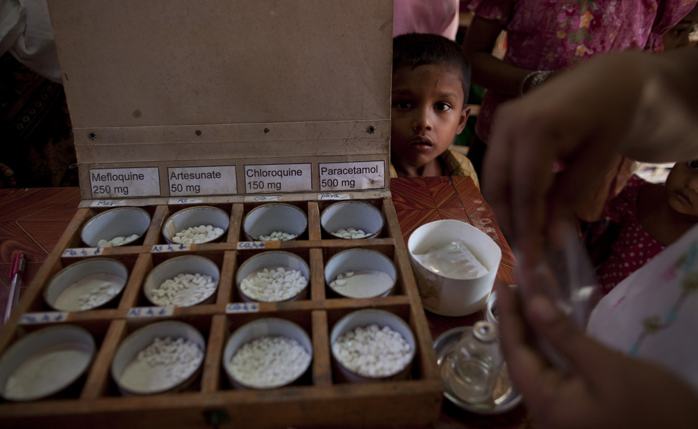 A boy watches as malaria medicine is given out to patients at a malaria clinic in Sittwe, Myanmar. Shoddy and phony malaria drugs are a longstanding problem in the country.