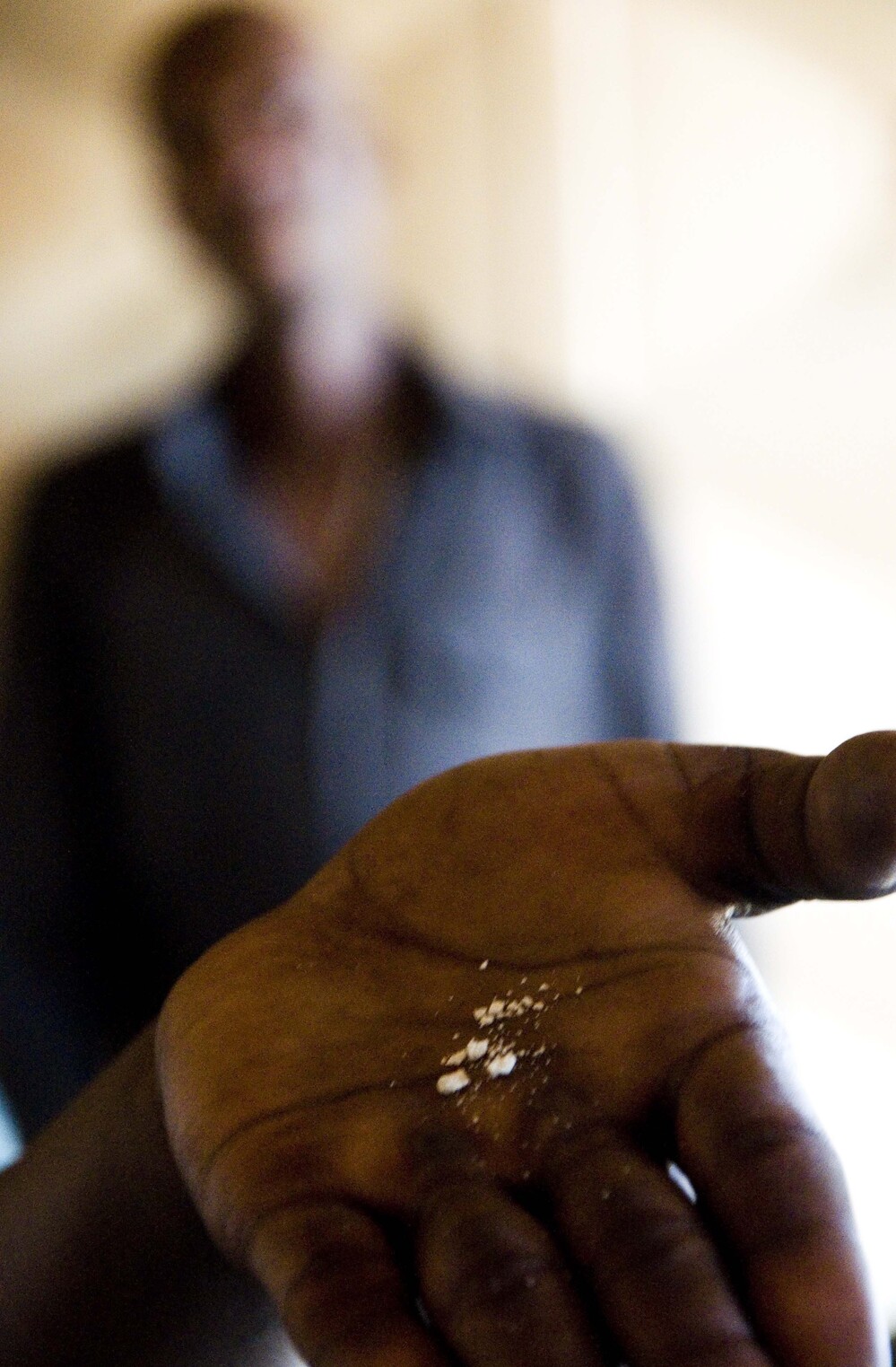 A whoonga smoker near Durban, South Africa, shows a crushed AIDS pill in the palm of his hand before mixing the drug with marijuana.
