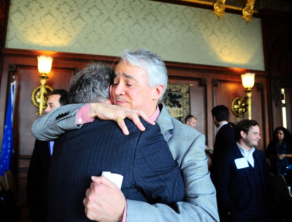 Following the Military Voices launch event, NPR Weekend Edition Saturday host Scott Simon hugs Gordon Bolar, General Manager of NPR Member Station WMUK in Kalamazoo, Michigan. In 2007, Bolar's son Matthew was killed by a roadside bomb in Iraq.