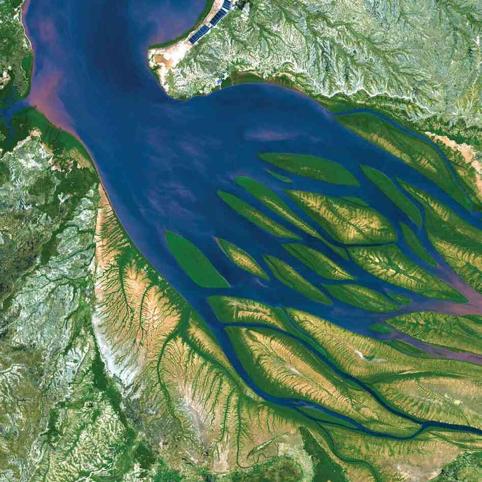 Bombetoka Bay, Madagascar, 2000Islands and sandbars have formed where the Betsiboka River flows into the Mozambique Channel. The past few decades have seen a dramatic increase in the amount of sediment moved by the river and deposited in the estuary. Dense vegetation is deep green, and water is sapphire, tinged with pink where sediment is particularly thick.