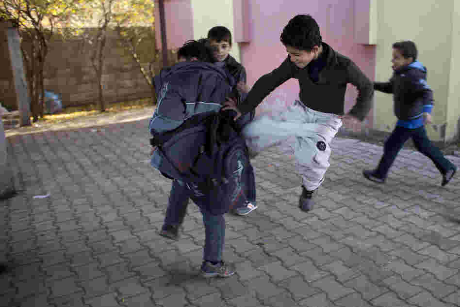 Some Syrian children play at wrestling and fighting during recess at the Albashayer School for Syrian Refugee Children. This type of play can be common among children who have witnessed traumatic events. Some Syrian children play at wrestling and fighting during recess at the Albashayer School for Syrian Refugee Children. This type of play can be common among children who have witnessed traumatic events.