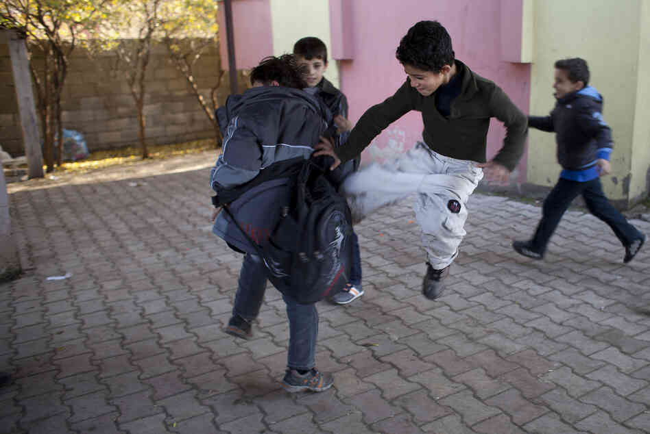 Some Syrian children play at wrestling and fighting during recess at the Albashayer School for Syrian Refugee Children. This type of play can be common among children who have witnessed traumatic events. Some Syrian children play at wrestling and fighting during recess at the Albashayer School for Syrian Refugee Children. This type of play can be common among children who have witnessed traumatic events.