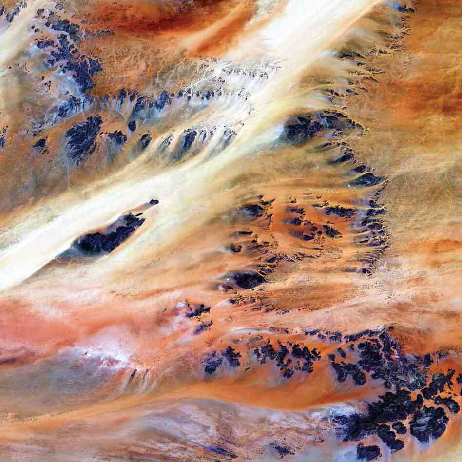 Terkezi Oasis, Chad, 2000A series of rocky outcroppings emerge from the sand in the Sahara Desert near the Terkezi Oasis. Stretching across the immense desert are vast plains of sand and gravel; seas of sand dunes; and barren, rocky mountains. Only 10,000 years ago, grasses covered the region, and mammals such as lions and elephants roamed the land.
