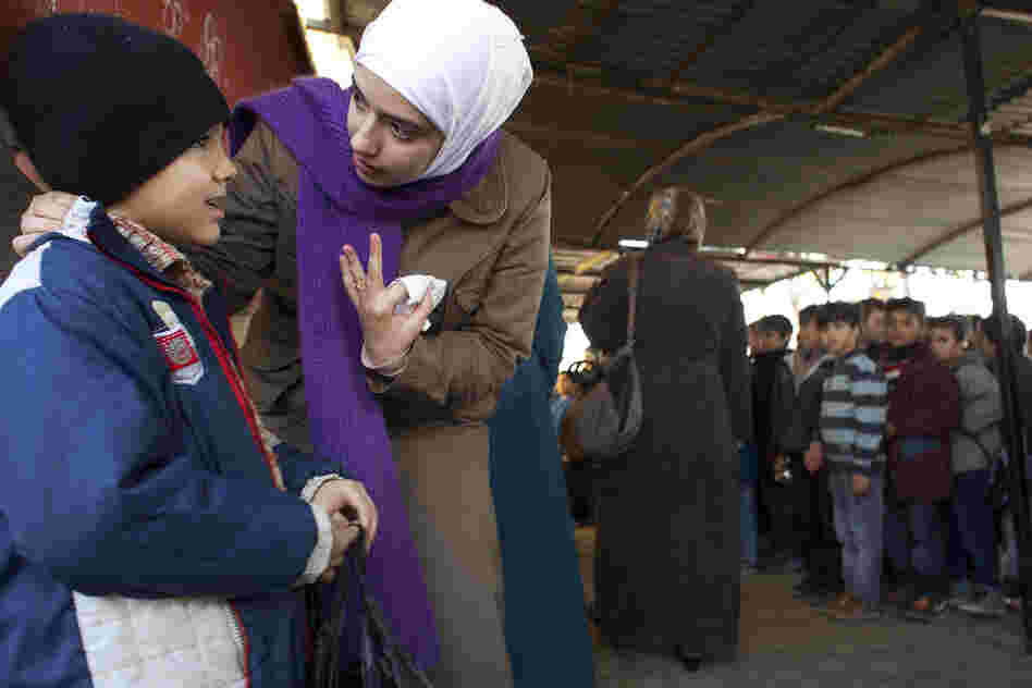 Teacher Rahaf Al Tinawie counsels a student outside class at the Albashayer School for Syrian Refugee Children. Al Tinawie says many children show signs of trauma and she sometimes meets with parents to discuss the problems the children are facing. Teacher Rahaf Al Tinawie counsels a student outside class at the Albashayer School for Syrian Refugee Children. Al Tinawie says many children show signs of trauma and she sometimes meets with parents to discuss the problems the children are facing.