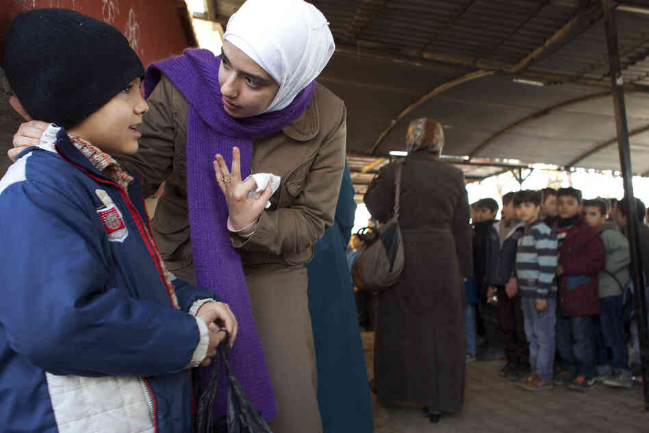 Teacher Rahaf Al Tinawie counsels a student outside class at the Albashayer School for Syrian Refugee Children. Al Tinawie says many children show signs of trauma and she sometimes meets with parents to discuss the problems the children are facing. Teacher Rahaf Al Tinawie counsels a student outside class at the Albashayer School for Syrian Refugee Children. Al Tinawie says many children show signs of trauma and she sometimes meets with parents to discuss the problems the children are facing.