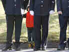 A child peers through firefighters standing as the procession heads to the cemetery outside the funeral for school shooting victim Daniel Barden at St. Rose of Lima Catholic Church in Newtown, Conn.,