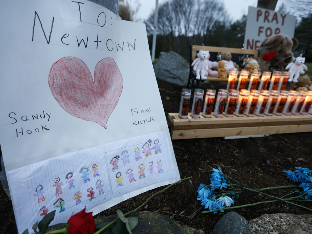 A child's message rests with a memorial for shooting victims on Sunday in Newtown, Conn.