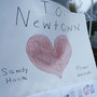 A child's message rests with a memorial for shooting victims on Sunday in Newtown, Conn.