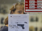 A clerk peers out from a gun shop in Seattle on Wednesday. A clerk peers out from a gun shop in Seattle on Wednesday.