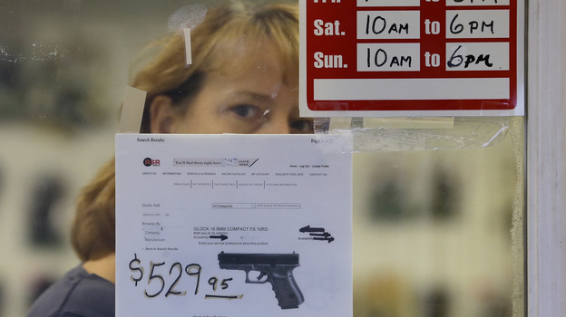 A clerk peers out from a gun shop in Seattle on Wednesday.