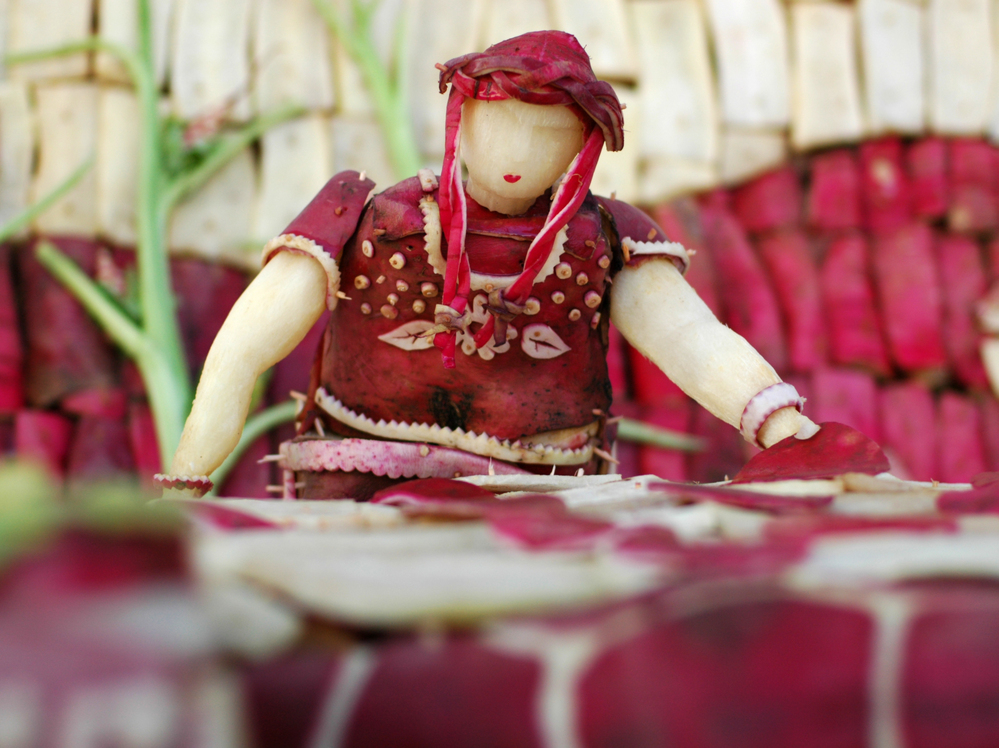 This radish woman appears to be making tortillas. This radish woman appears to be making tortillas.