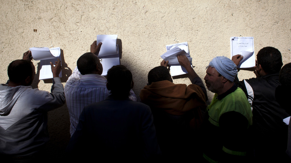 Egyptian voters check voter lists outside a polling station during the second round of a referendum on a disputed constitution drafted by Islamist supporters of president Mohammed Morsi, in Giza, Egypt on Saturday. Egyptian voters check voter lists outside a polling station during the second round of a referendum on a disputed constitution drafted by Islamist supporters of president Mohammed Morsi, in Giza, Egypt on Saturday.