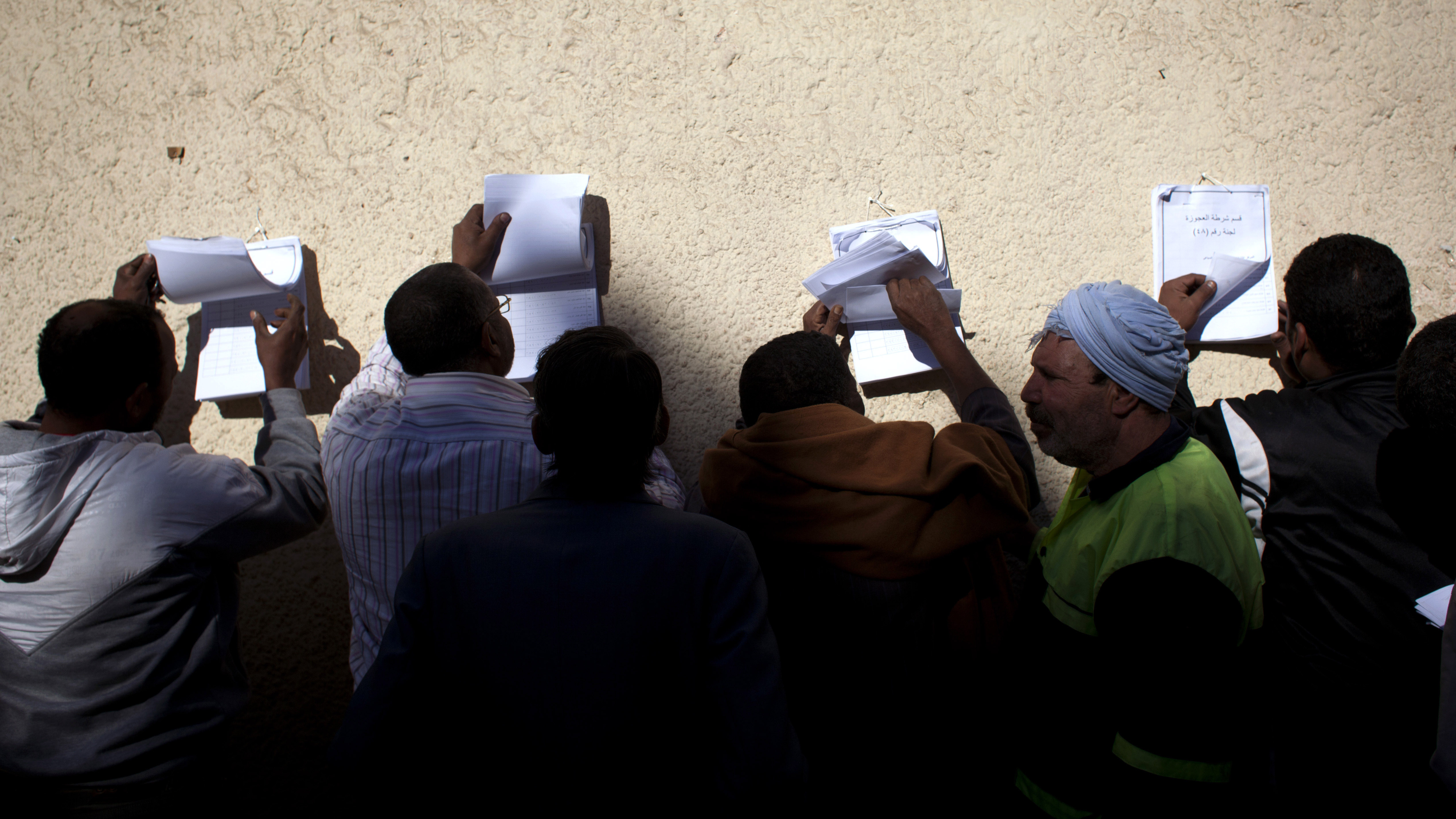 Egyptian voters check voter lists outside a polling station during the second round of a referendum on a disputed constitution drafted by Islamist supporters of president Mohammed Morsi, in Giza, Egypt on Saturday. Egyptian voters check voter lists outside a polling station during the second round of a referendum on a disputed constitution drafted by Islamist supporters of president Mohammed Morsi, in Giza, Egypt on Saturday.