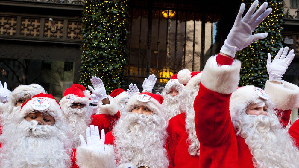 Charity workers dressed as Santa Claus wave to pedestrians in New York. Professional Santas say it's not an easy job, and it's not just as simple as putting on a beard. Charity workers dressed as Santa Claus wave to pedestrians in New York. Professional Santas say it's not an easy job, and it's not just as simple as putting on a beard.