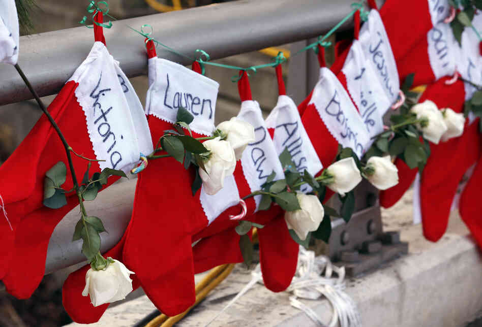 Christmas stockings with the names of shooting victims hang from a railing in the Sandy Hook village of Newtown, Conn.