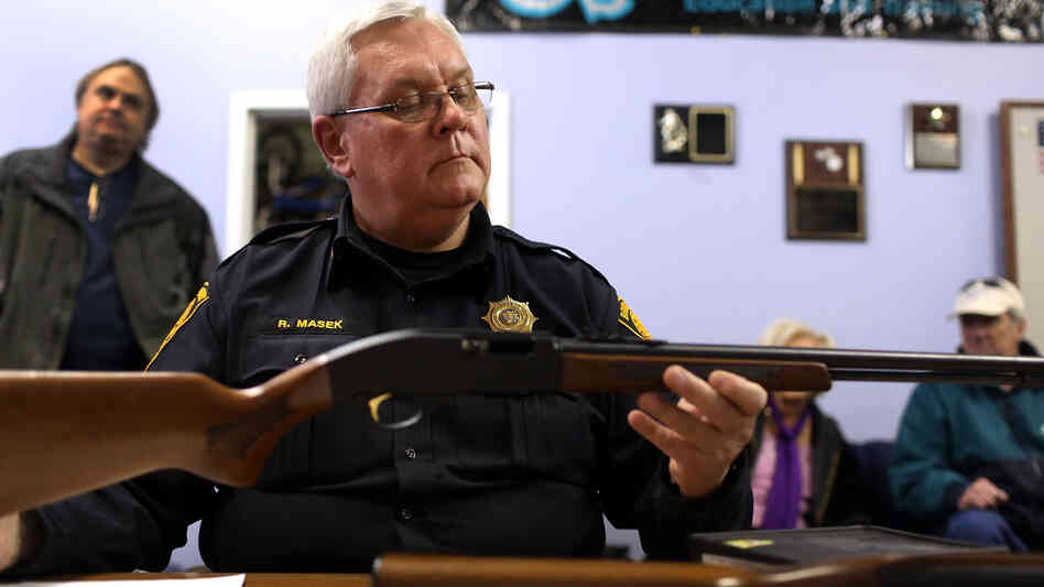 Police Lt. Ray Mesek registers a rifle at a gun buyback event on Saturday in Bridgeport, Conn.