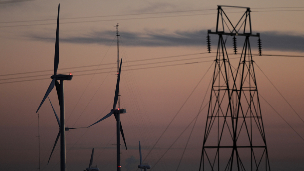 Wind turbines stand alongside an electrical tower at the National Wind Technology Center, run by the U.S. Department of Energy, outside Boulder, Colo.