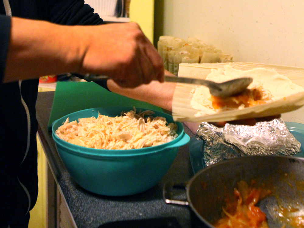 Crespo assembles tamales in his kitchen in the evening.