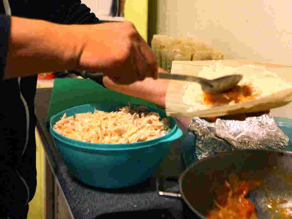 Crespo assembles tamales in his kitchen in the evening. Crespo assembles tamales in his kitchen in the evening.