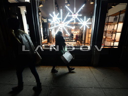 Friday evening in Manhattan, a woman with shopping bags passed by a store decorated for the holidays. Friday evening in Manhattan, a woman with shopping bags passed by a store decorated for the holidays.