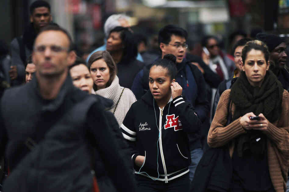A crowd crosses the street in midtown Manhattan.