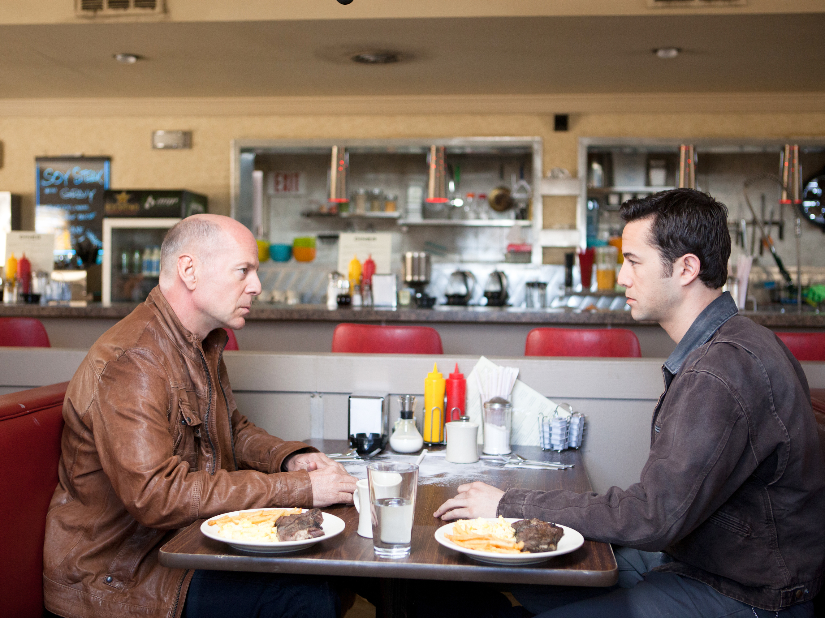 Young Joe (Joseph Gordon-Levitt) and Old Joe, the same man at two different moments of his life, stare each other down.