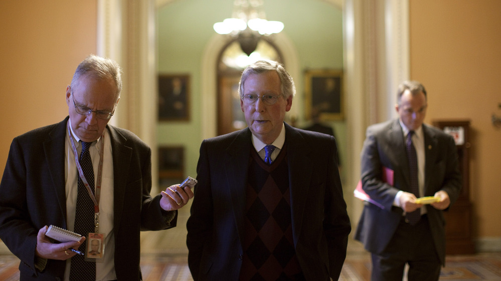 Senate Minority Leader Mitch McConnell walks toward his office after speaking on the Senate floor on Capitol Hill. McConnell and other congressional leaders will meet with President Obama Friday.