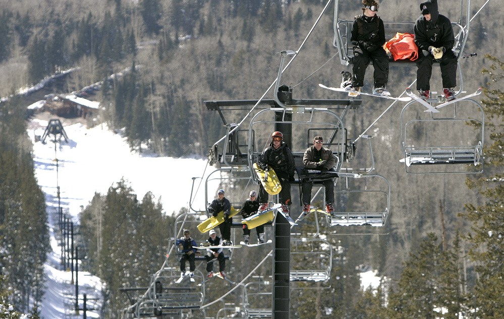 The Arizona Snowbowl resort began making snow exclusively with reclaimed wastewater this week. In this file photo, employees go up a ski lift at the resort.