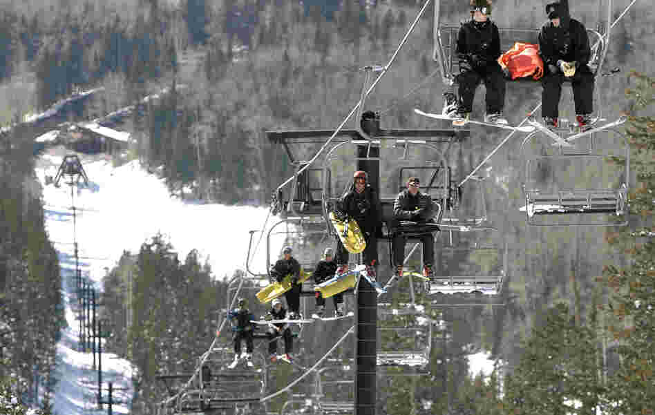 The Arizona Snowbowl resort began making snow exclusively with reclaimed wastewater this week. In this file photo, employees go up a ski lift at the resort.