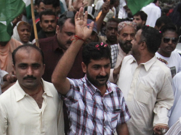 Uzair Baloch (center), 32, controls an impoverished section of Karachi and commands a large armed force. He is routinely described as a gangster, though he calls himself a politician and a social worker. He's shown here at a rally in Karachi in November 2011.