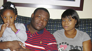 Natisha Laws and her partner, Mark Douglas, inside the Times Square hotel room where they've been staying since mid-November. The tourist hot spot is exciting for 3-year-old Tru and 9-year-old Isaiah, but their parents say they are stressed out and worry the family will end up homeless.