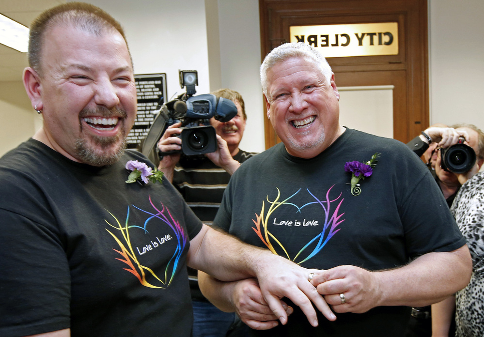 Steven Bridges (left) receives a wedding ring from Michael Snell, early Saturday at City Hall in Portland, Maine. Same-sex couples in Maine are now legally allowed to marry under a new law that went into effect at 12:01 a.m.
