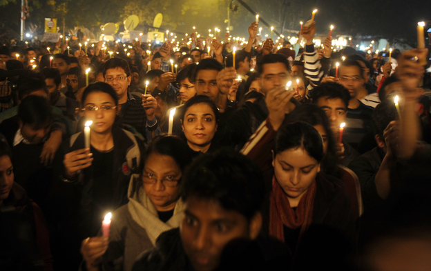 Protesters hold candles during a rally in New Delhi late Saturday following the death of a woman gang-raped on a bus.