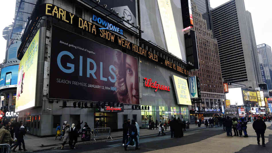 Pedestrians pass the Dow Jones display ticker in Times Square on Wednesday in New York. U.S. shoppers spent cautiously this holiday season, a disappointment for retailers that slashed prices to lure people into stores and now must hope for a post-Christmas burst of spending.
