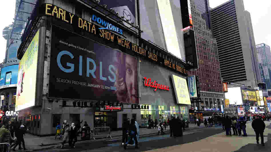Pedestrians pass the Dow Jones display ticker in Times Square on Wednesday in New York. U.S. shoppers spent cautiously this holiday season, a disappointment for retailers who slashed prices to lure people into stores and now must hope for a post-Christmas burst of spending.